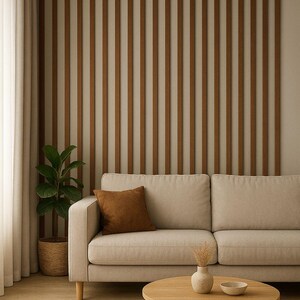 May include: A modern living room scene featuring a beige sofa with a brown cushion, a round wooden coffee table, and a potted plant. The wall has vertical wooden slats. The room has a neutral color palette.