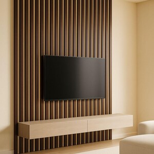 May include: A modern living room with a dark wood slatted wall paneling. A large black flat-screen television is mounted on the wall. Below the TV is a light wood floating cabinet. A beige rug and seating complete the space.