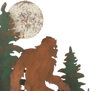 May include: Metal wall art featuring a silhouette of Bigfoot walking through a forest with a full moon in the background. The art is painted in shades of brown, green, and white.