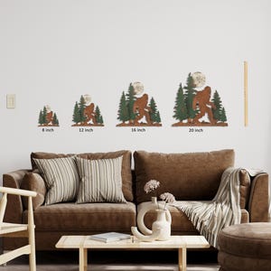 May include: Four different sizes of metal wall art featuring a Bigfoot silhouette walking through a forest with a full moon. The sizes are 8 inches, 12 inches, 16 inches, and 20 inches.