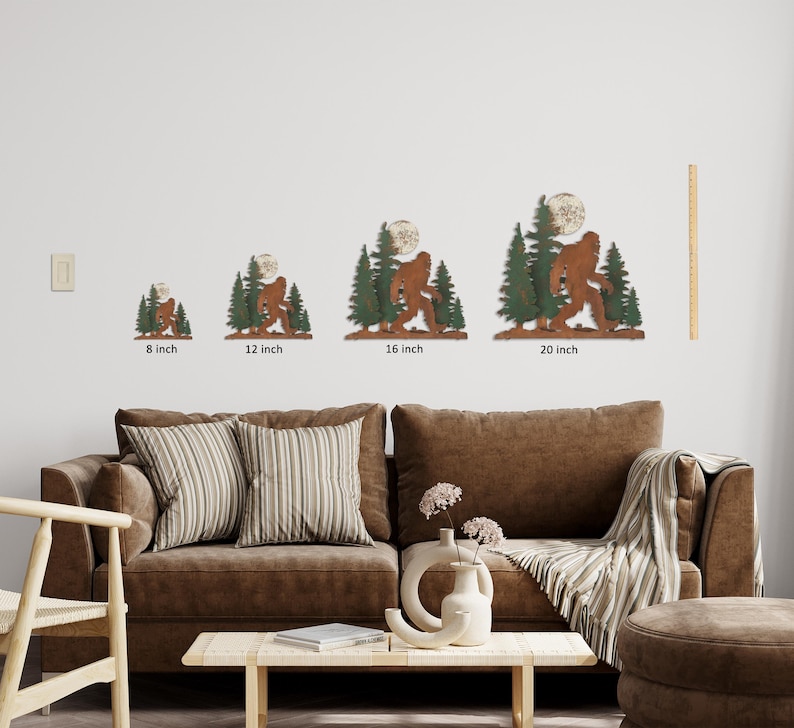 May include: Four different sizes of metal wall art featuring a Bigfoot silhouette walking through a forest with a full moon. The sizes are 8 inches, 12 inches, 16 inches, and 20 inches.