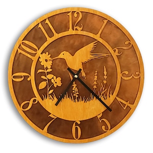 May include: A wooden clock with a hummingbird and flowers design. The clock face has Roman numerals and a black hour and minute hand. The clock is 12 inches in diameter.
