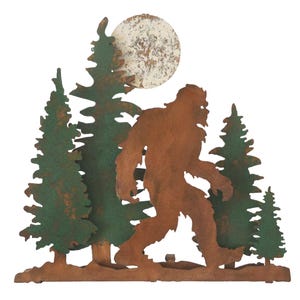 May include: Metal wall art featuring a silhouette of Bigfoot walking through a forest with a full moon in the background. The trees and Bigfoot are rusty brown and green.