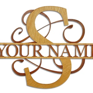May include: Wooden sign with a decorative 'S' initial and the text 'YOUR NAME' in a split monogram style. The 'S' is in a light brown color and the text is in a darker brown color.