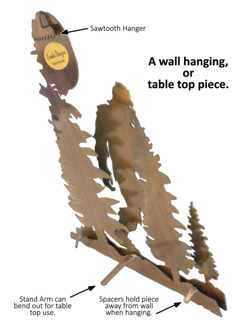 May include: A metal wall hanging or table top piece depicting a forest scene with three trees. The piece has a sawtooth hanger on the back and a stand that can be bent out for table use. The piece is made by Crooks Designs.