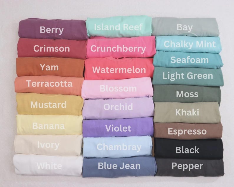 May include: A collection of folded fabric in various colors, including Berry, Crimson, and Yam. Each fabric piece has a color name printed on it in white. Other colors include Island Reef, Crunchberry, and Chalky Mint.