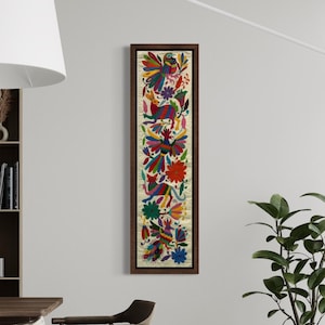 Peut inclure: Une œuvre d'art textile verticale encadrée, avec un motif floral et aviaire vibrant. L'œuvre présente un fond crème avec des fleurs, des oiseaux et des feuilles brodés colorés en rouge, bleu, vert et jaune. Le cadre est de couleur marron foncé.