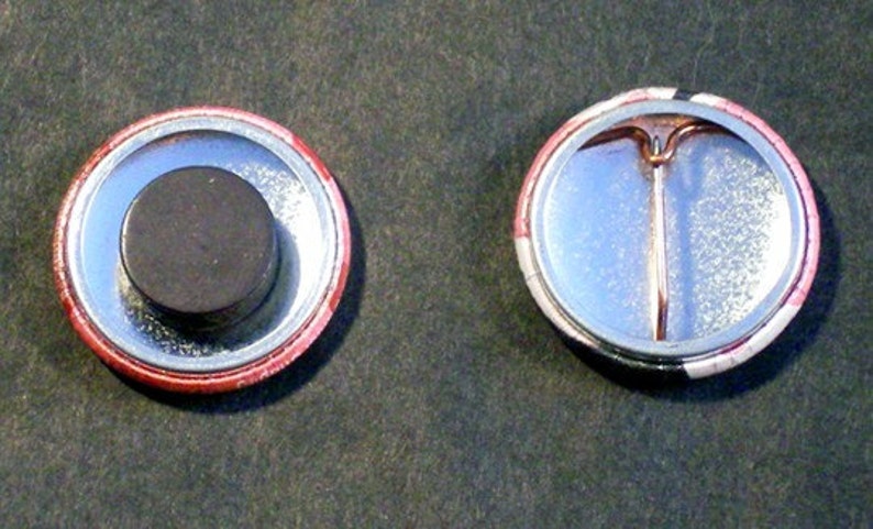 This image shows the backs of two 1 inch round pin-back buttons. The one on the left has a magnet instead of a pin and the one on the right has a pin for wearing on clothes, tote bags, hats, etc.