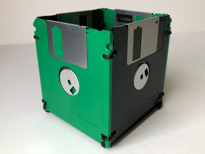 A diskette container shown in green and black with black cable tie fasteners.