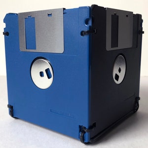 A diskette container shown in blue and black with black cable tie fasteners.