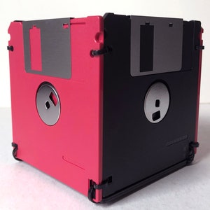 A diskette container shown in red and black with black cable tie fasteners.