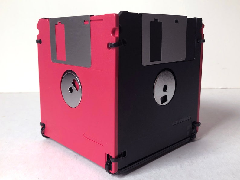 A diskette container shown in red and black with black cable tie fasteners.