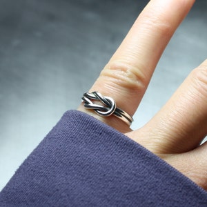 Model showing sterling silver Celtic sailor knot ring on finger.