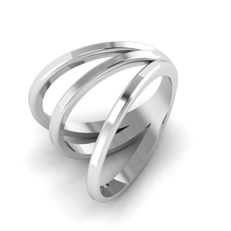 Puede incluir: Un anillo de plata con tres bandas entrelazadas. Las bandas son lisas y pulidas.