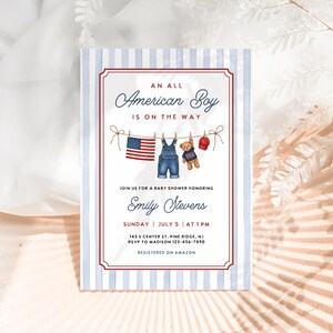 May include: Baby shower invitation with a patriotic theme. The invitation features a red and blue striped border and the text "An All American Boy Is On The Way." The design includes a clothesline with a small American flag, denim overalls, a teddy bear, and a baseball cap.