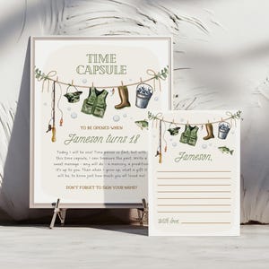 May include: A printable time capsule for a birthday celebration. The card features a fishing theme with a green vest, fishing rod, and a bucket. The text on the card reads "Time Capsule, To be opened when Jameson turns 18. Today I will be one! Time passes so fast, but with this time capsule, I can treasure the past, write a sweet message, any will do - a memory, a prediction it's up to you. Then when I grow up, what a gift it will be to know just how much you all loved me! Don't forget to sign your name!"
