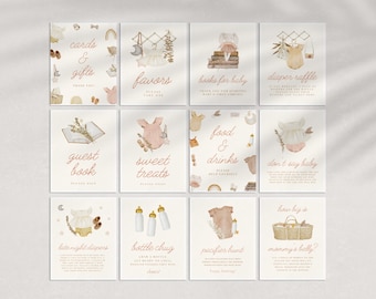 May include: A set of 12 printable baby shower signs with a watercolor design featuring a baby onesie, a book, a basket, and a bottle. The signs include titles such as "Cards & Gifts", "Favors", "Books for Baby", "Diaper Raffle", "Guest Book", "Sweet Treats", "Food & Drinks", "Don't Say Baby", "Late Night Diapers", "Bottle Chug", "Pacifier Hunt", and "How Big is Mommy's Belly?"