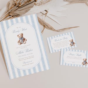 May include: Baby shower stationery set featuring a teddy bear illustration. The invitation has blue and white stripes and text that reads "Beauity Wait" and "Mila Baker". Includes inserts for "Books for Baby" and "Diaper Raffle".