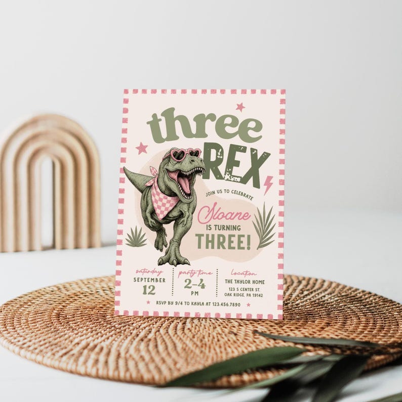 May include: A rectangular birthday invitation card featuring a green T-Rex wearing heart-shaped sunglasses and a pink checkered bandana. The text reads three REX, Sloane IS TURNING THREE, with event details for September 12, 2-4 PM at The Taylor Home.