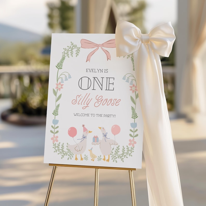 Puede incluir: Un cartel blanco con un borde floral y un lazo rosa. El cartel dice "Evelyn is One Silly Goose" y "Welcome to the Party!" Hay dos gansos de dibujos animados con sombreros de fiesta y globos.