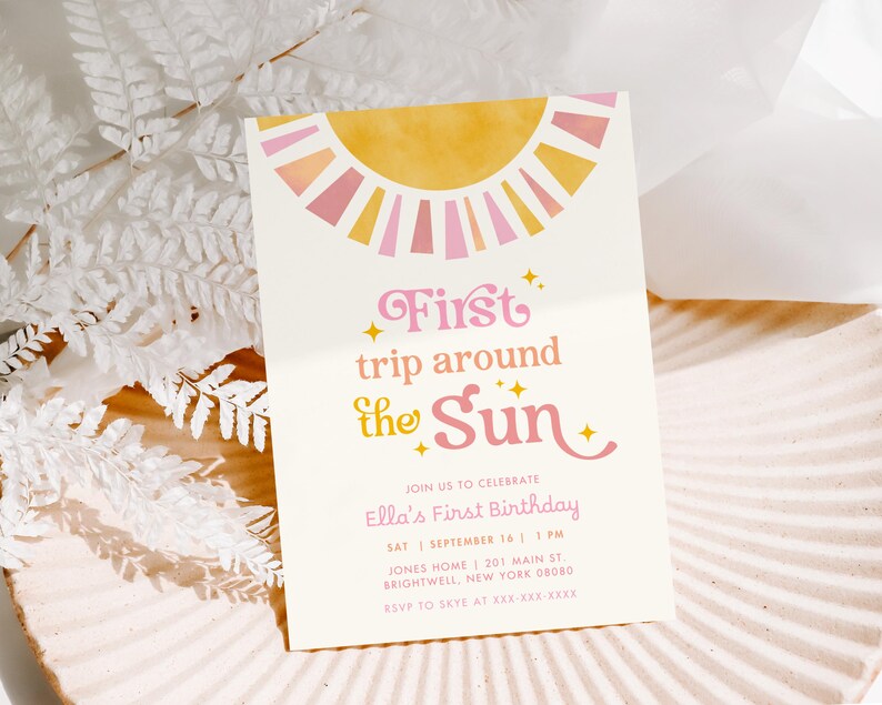 May include: A cream-colored invitation with a sun design in yellow and pink. The text reads "First trip around the Sun" in pink script. Additional text includes birthday details and RSVP information.
