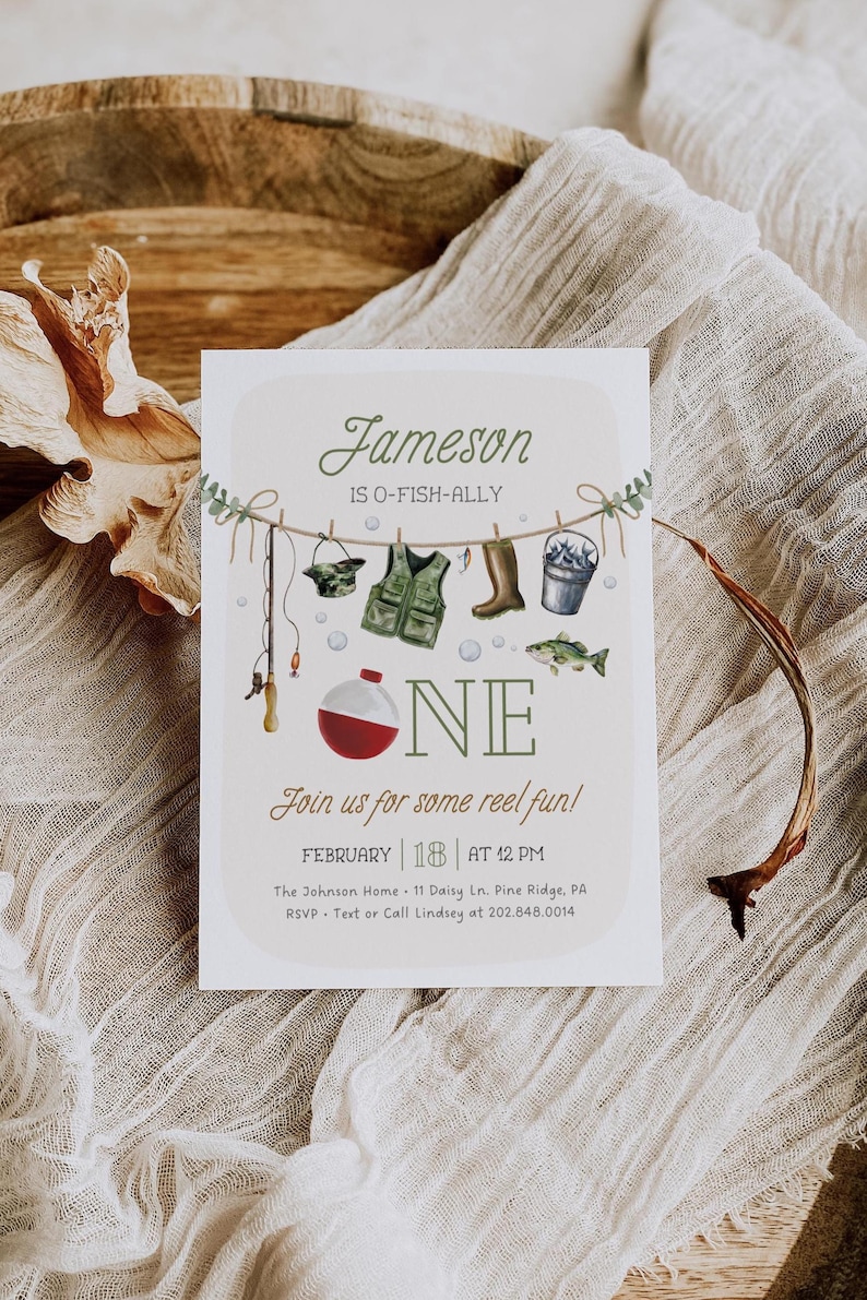 May include: A light blue and green illustrated invitation for a first birthday party. The invitation features a fishing theme with a fishing rod, a life vest, boots, a bucket, and a fish. The text on the invitation reads "Jameson is O-Fish-Ally One. Join us for some reel fun! February 18 at 12 PM. The Johnson Home 11 Daisy Ln. Pine Ridge, PA. RSVP - Text or Call Lindsey at 202.848.0014."
