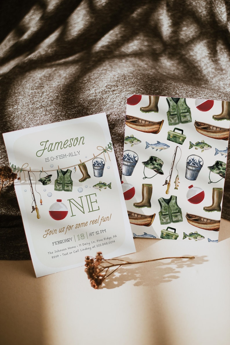 May include: A white invitation with a watercolor illustration of fishing gear hanging on a clothesline. The text reads "Jameson is O-Fish-Ally One. Join us for some reel fun! February 18 at 12 PM. The Johnson Home 11 Daisy Ln. Pine Ridge, PA. RSVP - Text or Call Lindsey at 202.848.0014."