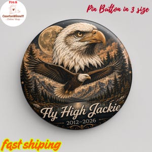 Op de afbeelding: Een ronde pin button met een Amerikaanse zeearend en een vliegende adelaar boven een bergmeerlandschap met een volle maan. De tekst Fly High Jackie 2012-2026 staat in een cursief lettertype. Het kleurenpalet bevat tinten bruin, goud en zwart.