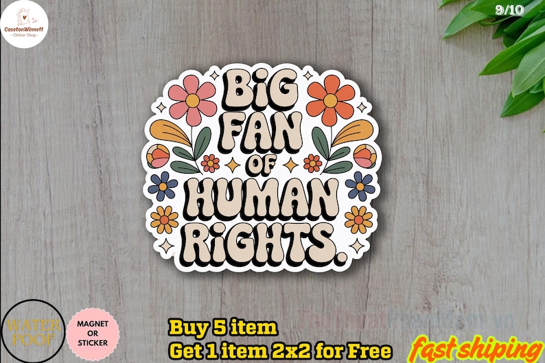 May include: A sticker with the text "BIG FAN OF HUMAN RIGHTS" in a retro font, surrounded by colorful flowers and leaves. The sticker is white with a black outline and is on a wooden surface. The sticker is a magnet or sticker.
