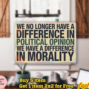 May include: A rectangular magnet or sticker with the text "WE NO LONGER HAVE A DIFFERENCE IN POLITICAL OPINION WE HAVE A DIFFERENCE IN MORALITY" in black, green, and red. The background is a light tan color.