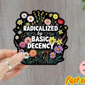 Op de afbeelding: Een zwarte sticker met een bloemenontwerp en de woorden "RADICALIZED by BASIC DECENCY" in het wit. De sticker bevat verschillende kleurrijke bloemen, waaronder madeliefjes, rozen en zonnebloemen. De sticker is waterdicht.