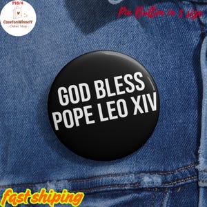 May include: A black circular badge with the white text "GOD BLESS POPE LEO XIV". The badge is set against a blue denim background. The badge is a pin button.