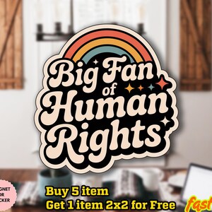 以下が含まれることがあります： レトロなフォントで「Big Fan of Human Rights」の文字と虹のデザインが施された、クリーム色のステッカーまたはマグネット。ステッカーは黒い縁取りとカラフルなアクセントが特徴です。