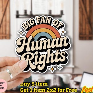 May include: A sticker with the text "BIG FAN OF Human Rights" in a retro font, with a rainbow design. The sticker is held by a hand. The sticker is water-proof and can be used as a magnet.