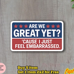 May include: A rectangular sticker with a white border, featuring the text "ARE WE GREAT YET?" in white on a blue background with red stars. Below, the text "'CAUSE I JUST FEEL EMBARRASSED." is in white on a red background.