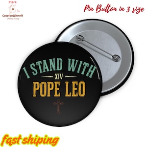 May include: Black pin badge with the text "I STAND WITH POPE LEO" in teal and gold. The badge has a silver backing and a safety pin clasp. The image also includes the text "Pin Button in 3 size".