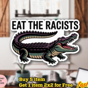 May include: A sticker with a cartoon alligator and the words "EAT THE RACISTS". The alligator is green, purple, and tan. The sticker is on a white background.