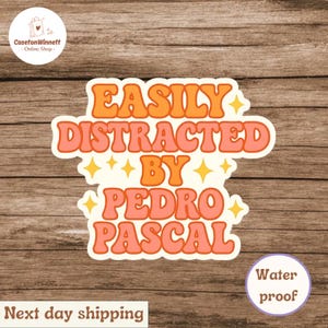 May include: A white sticker with the text "EASILY DISTRACTED BY PEDRO PASCAL" in orange and pink bubble letters. The sticker has a retro design with star accents. The sticker is waterproof.