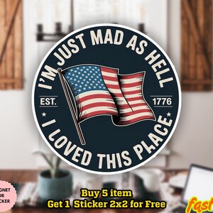 May include: A round sticker with the text "I'M JUST MAD AS HELL I LOVED THIS PLACE" encircling an American flag. The sticker also includes the text "EST. 1776". The sticker is water-proof and can be used as a magnet or sticker.