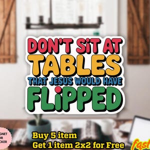 May include: A colorful sticker with the text "DON'T SIT AT TABLES THAT JESUS WOULD HAVE FLIPPED". The text is in a bold, retro font with red, yellow, blue, and green colors. The sticker is waterproof and can be used as a magnet.