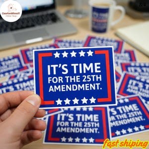 Op de afbeelding: Een blauwe sticker met rode en witte accenten, met de tekst "IT'S TIME FOR THE 25TH AMENDMENT." De rechthoekige sticker heeft witte sterren aan de boven- en onderkant. Er zijn meerdere stickers zichtbaar.