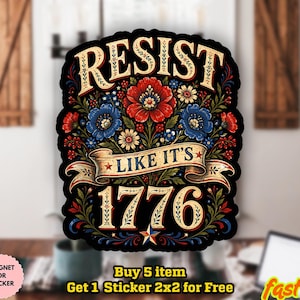 Op de afbeelding: Een gestanste sticker met een zwarte achtergrond en een centraal bloemstuk van rode en blauwe bloemen. De tekst RESIST staat in een boog bovenaan, met een banner met de tekst LIKE IT'S en het grote getal 1776 onderaan, geaccentueerd door een ster.