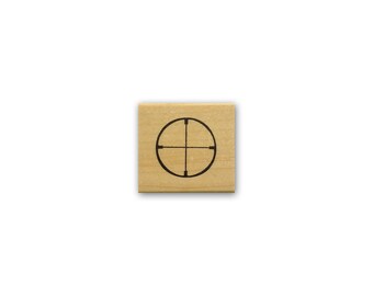 Könnte beinhalten: Ein Stempel aus Holz mit einem schwarzen Kreis und Fadenkreuz in der Mitte.