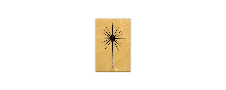 Op de afbeelding: Een houten stempel met een zwart silhouet van een ster met een lange punt.