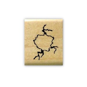May include: A wooden rubber stamp with a black design of a cracked or broken surface.
