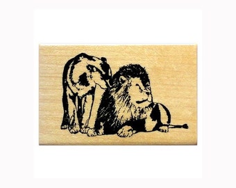 May include: Black and white silhouette of a lion and a bear on a wooden background.