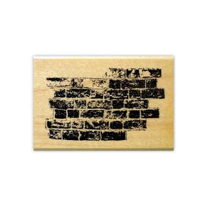 May include: A wooden rubber stamp with a black and white design of a brick wall.