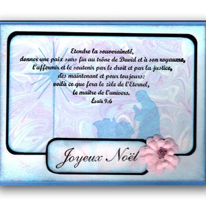 Op de afbeelding: Een blauwe en roze marmeren achtergrond met een zwart frame en een witte ster. De tekst "Etendre la souverainet&eacute;, donner une paix sans fin au tr&ocirc;ne de David et &agrave; son royaume, l'affermir et le soutenir par le droit et par la justice, des maintenant et pour toujours: voil&agrave; ce que fera le z&egrave;le de l'Eternel, le ma&icirc;tre de l'univers. &Eacute;sa&iuml;e 9:6" is in het zwart geschreven. De tekst "Joyeux No&euml;l" is in zwarte cursieve letters geschreven. Een roze bloem bevindt zich in de rechterbenedenhoek.