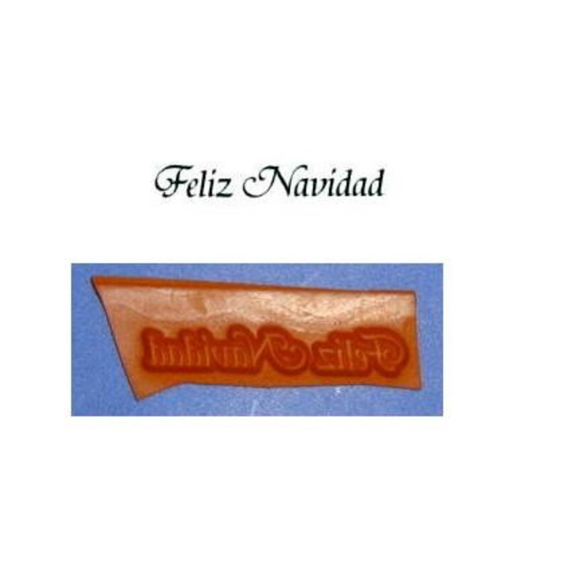 May include: A brown rubber stamp with the words "Feliz Navidad" in a decorative font.