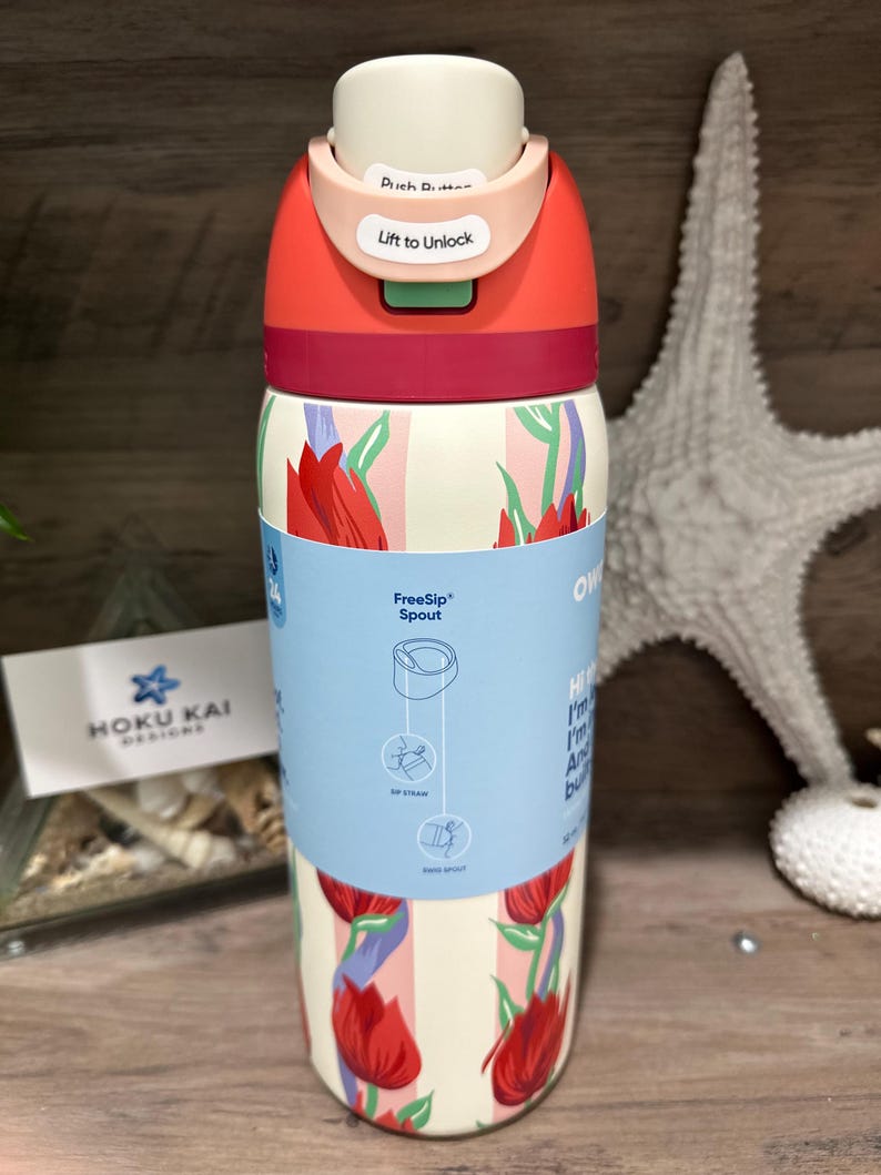 May include: A stainless steel water bottle with a floral design. The bottle has a red and white color scheme with a push-button lid that says "Lift to Unlock". The bottle has a FreeSip spout and is 16 oz.